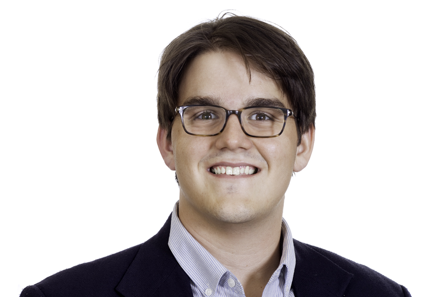 This Brian Charles Steel photo is a headshot of a white gentleman wearing a black sport coat, and a dress shirt with white and blue stripes.  He has brown straight hair that is combed to the left.  The gentleman is wearing glasses and a smile.  He is centered in the frame, and the background is completely white.  He is lit with a slight Rembrandt style. 